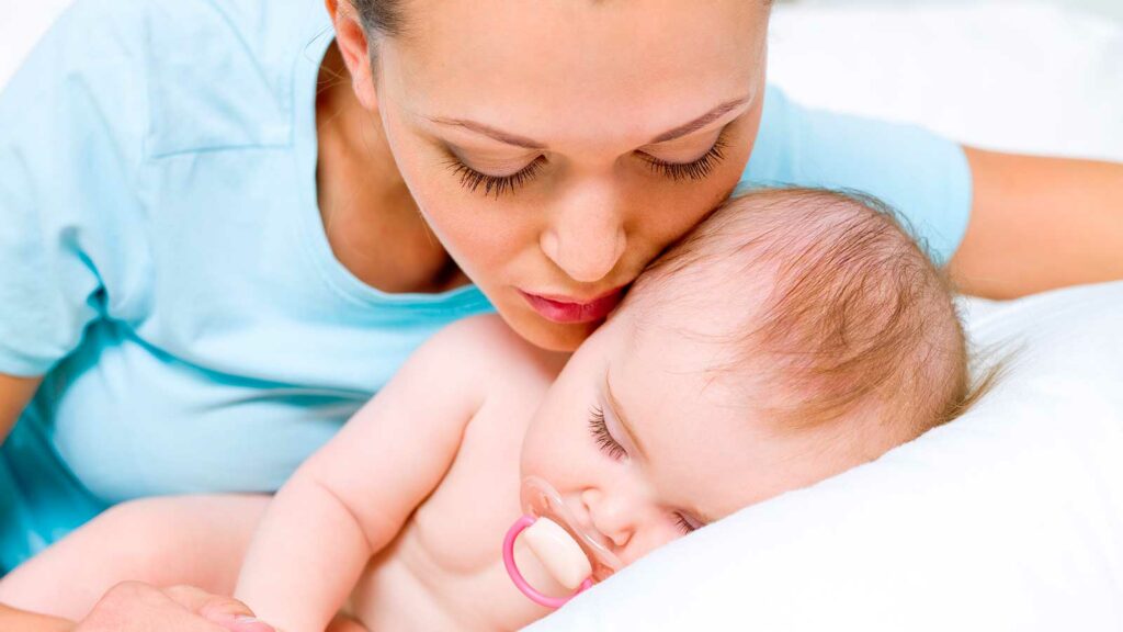 Mamá susurrando a su bebé los beneficios del sueño